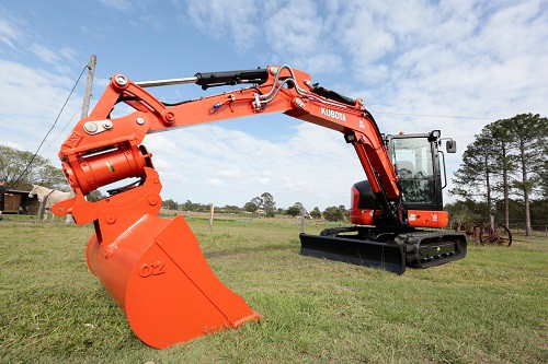 Kubota excavator on green grass in open field