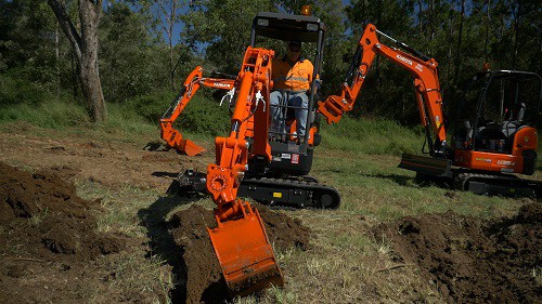 Mini excavator digging the earth using ANT tilt hitch attached to mud bucket 