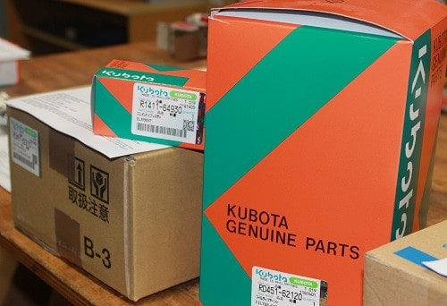 Kubota genuine parts in courier boxes piled on a table