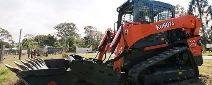Kubota track loader moving earth on a field